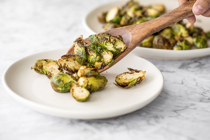 Tender and crispy roasted air fryer brussels sprouts cooks in less than 12 minutes with very little oil. It is a holiday table game changer. | aheadofthyme.com