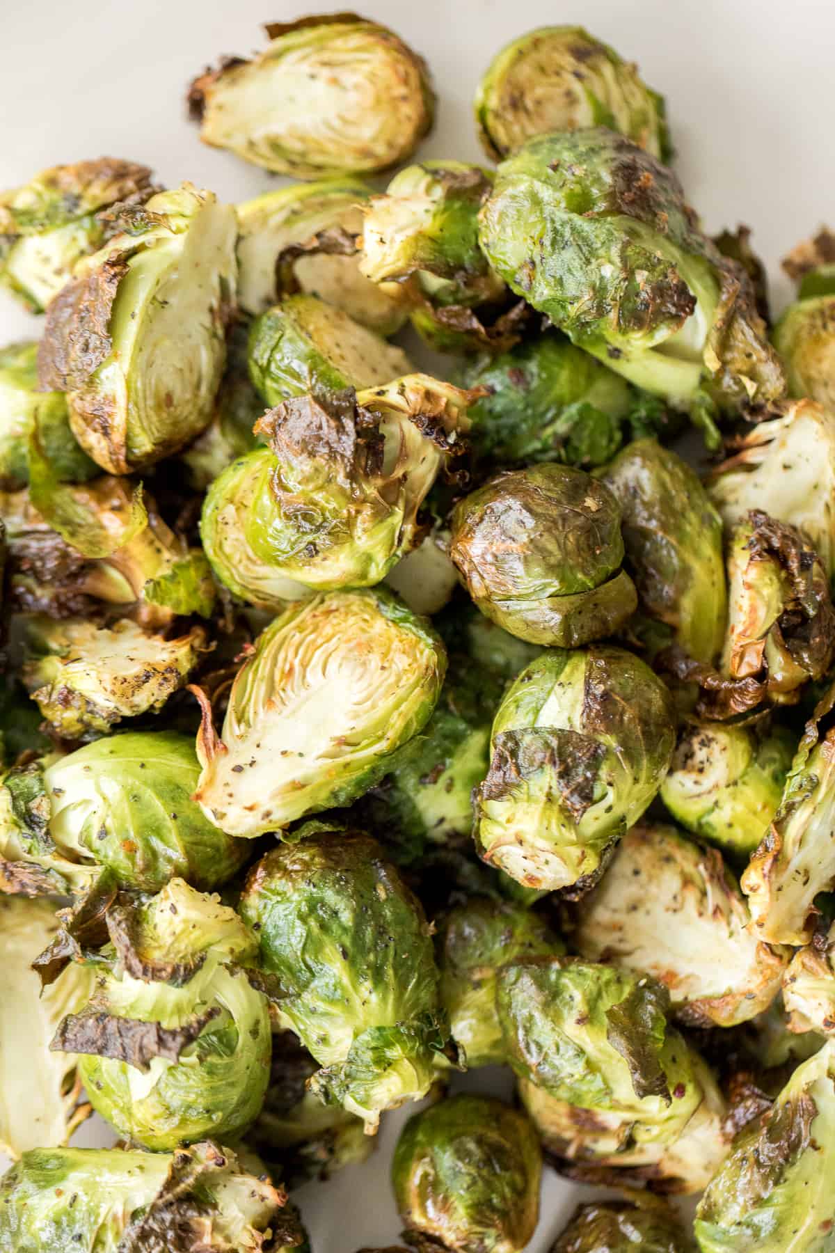 Tender and crispy roasted air fryer brussels sprouts cooks in less than 12 minutes with very little oil. It is a holiday table game changer. | aheadofthyme.com