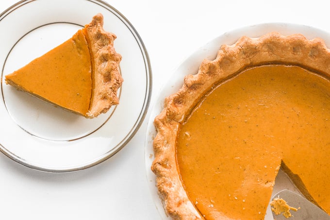 Thanksgiving just isn't the same without a slice of classic Thanksgiving pumpkin pie with flaky crust, smooth pumpkin filling, and topped with whipped cream and pecans. | aheadofthyme.com