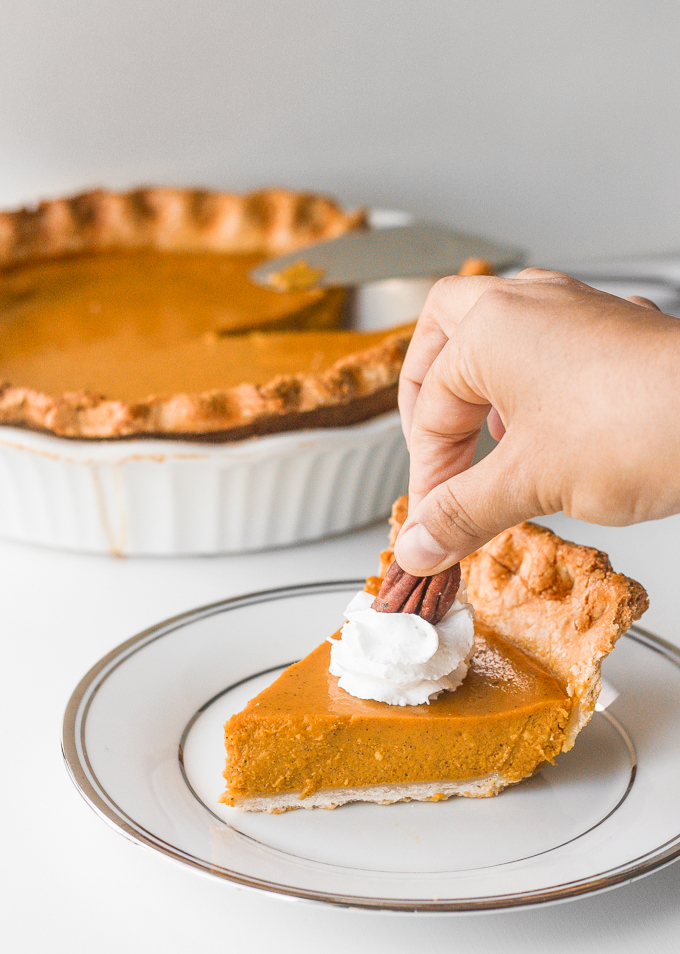 Thanksgiving just isn't the same without a slice of classic Thanksgiving pumpkin pie with flaky crust, smooth pumpkin filling, and topped with whipped cream and pecans. | aheadofthyme.com
