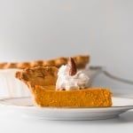 Thanksgiving just isn't the same without a slice of classic Thanksgiving pumpkin pie with flaky crust, smooth pumpkin filling, and topped with whipped cream and pecans. | aheadofthyme.com