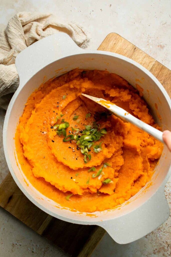 Creamy, buttery savory mashed sweet potatoes with garlic, herbs, and green onions is the perfect cozy side for dinner or holidays. | aheadofthyme.com