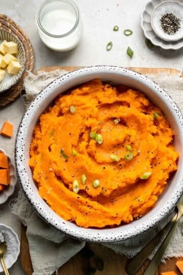 Creamy, buttery savory mashed sweet potatoes with garlic, herbs, and green onions is the perfect cozy side for dinner or holidays. | aheadofthyme.com