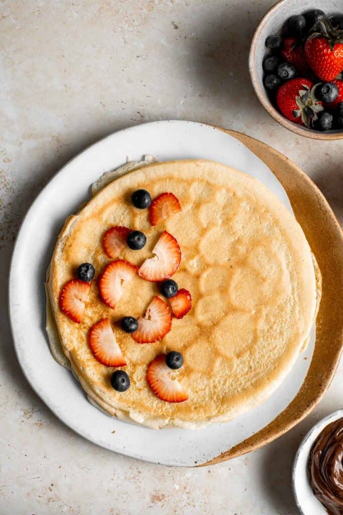 Nutella crepes with berries are sweet and indulgent. These French pancakes are an easy to make blender recipe that will have you craving breakfast all day. | aheadofthyme.com