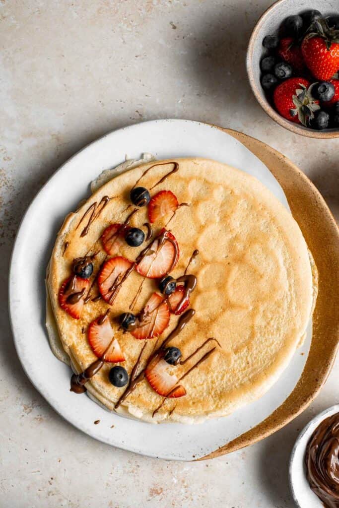 Nutella crepes with berries are sweet and indulgent. These French pancakes are an easy to make blender recipe that will have you craving breakfast all day. | aheadofthyme.com