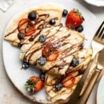 Nutella crepes with berries are sweet and indulgent. These French pancakes are an easy to make blender recipe that will have you craving breakfast all day. | aheadofthyme.com