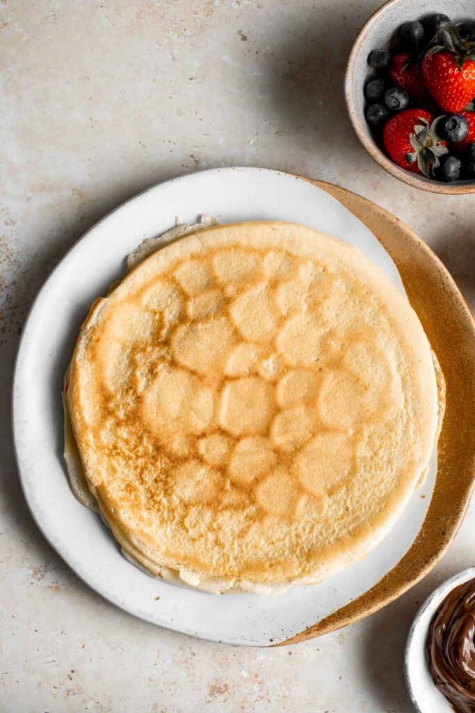 Nutella crepes with berries are sweet and indulgent. These French pancakes are an easy to make blender recipe that will have you craving breakfast all day. | aheadofthyme.com