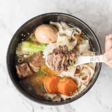 An easy weeknight dinner option, this hearty and oily slow cooker Asian beef noodle soup is packed with beef chunks, vegetables, noodles, and Asian spices and flavours. | aheadofthyme.com