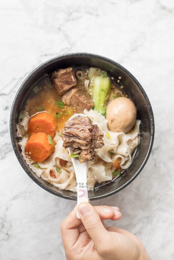 An easy weeknight dinner option, this hearty and oily slow cooker Asian beef noodle soup is packed with beef chunks, vegetables, noodles, and Asian spices and flavours. | aheadofthyme.com