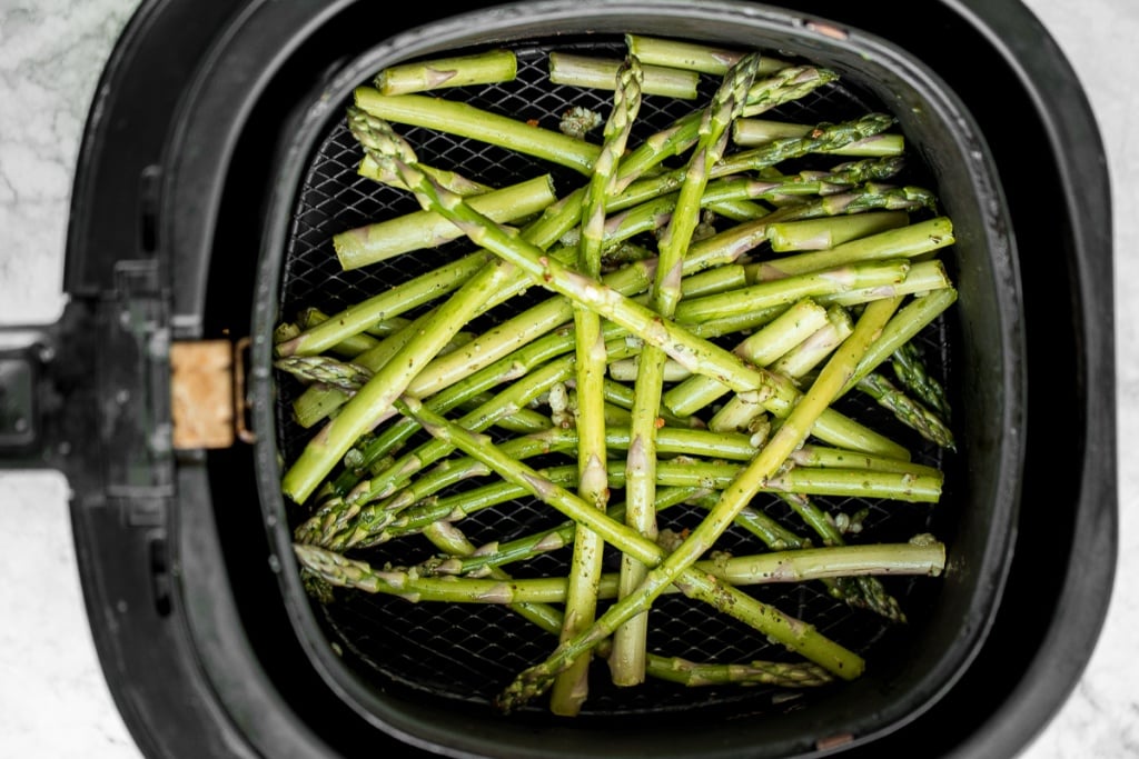 Crisp on the outside and tender inside, air fryer asparagus cooks in just 6 minutes! It is tossed in very little olive oil with garlic and seasonings. | aheadofthyme.com