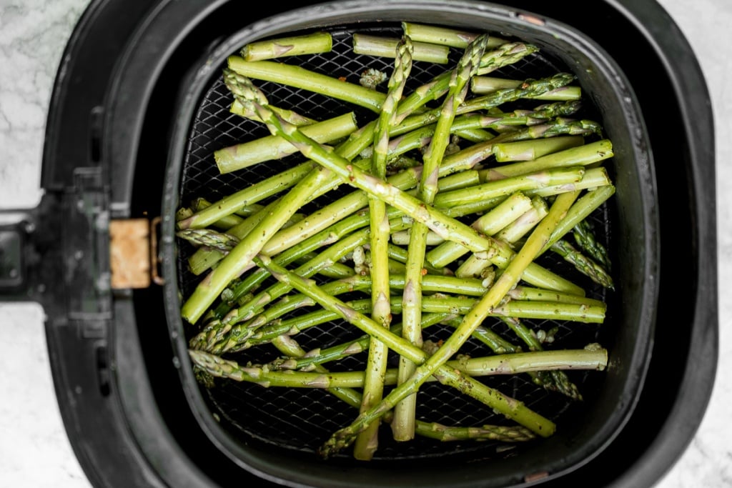 Crisp on the outside and tender inside, air fryer asparagus cooks in just 6 minutes! It is tossed in very little olive oil with garlic and seasonings. | aheadofthyme.com