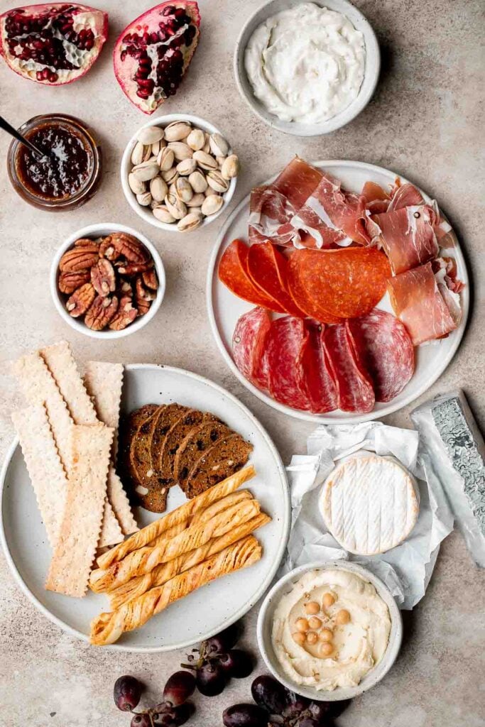 This easy charcuterie board is the perfect appetizer to impress with minimal effort— made with cheese, cured meats, crackers, dips, olives, fruit, and nuts. | aheadofthyme.com