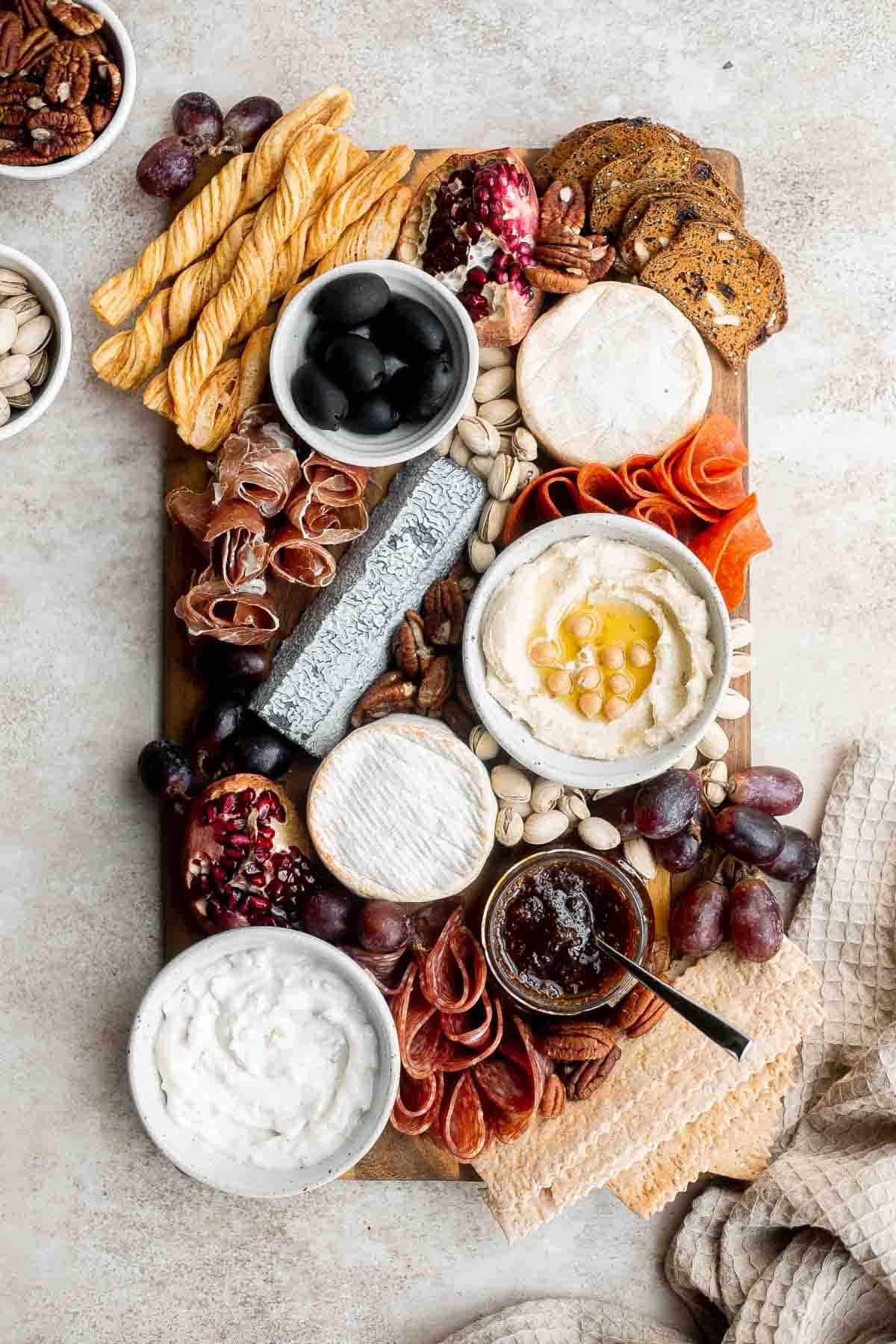 This easy charcuterie board is the perfect appetizer to impress with minimal effort— made with cheese, cured meats, crackers, dips, olives, fruit, and nuts. | aheadofthyme.com