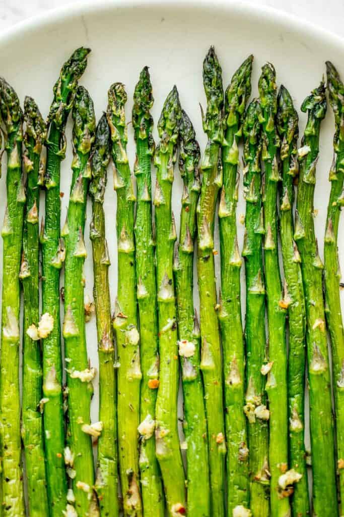 Crisp on the outside and tender inside, air fryer asparagus cooks in just 6 minutes! It is tossed in very little olive oil with garlic and seasonings. | aheadofthyme.com