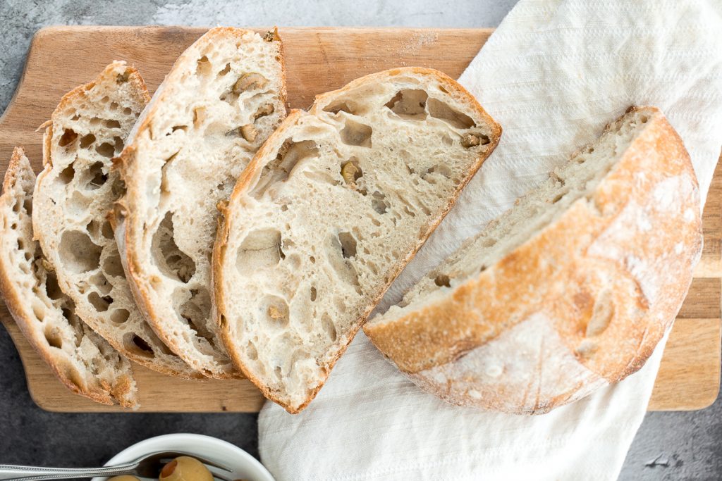 Artisan green olive sourdough bread is airy and chewy, has a signature crispy crust, and is loaded with tangy green olives for a Mediterranean flair. | aheadofthyme.com
