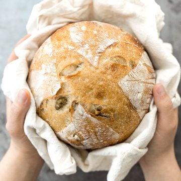 Artisan green olive sourdough bread is airy and chewy, has a signature crispy crust, and is loaded with tangy green olives for a Mediterranean flair. | aheadofthyme.com