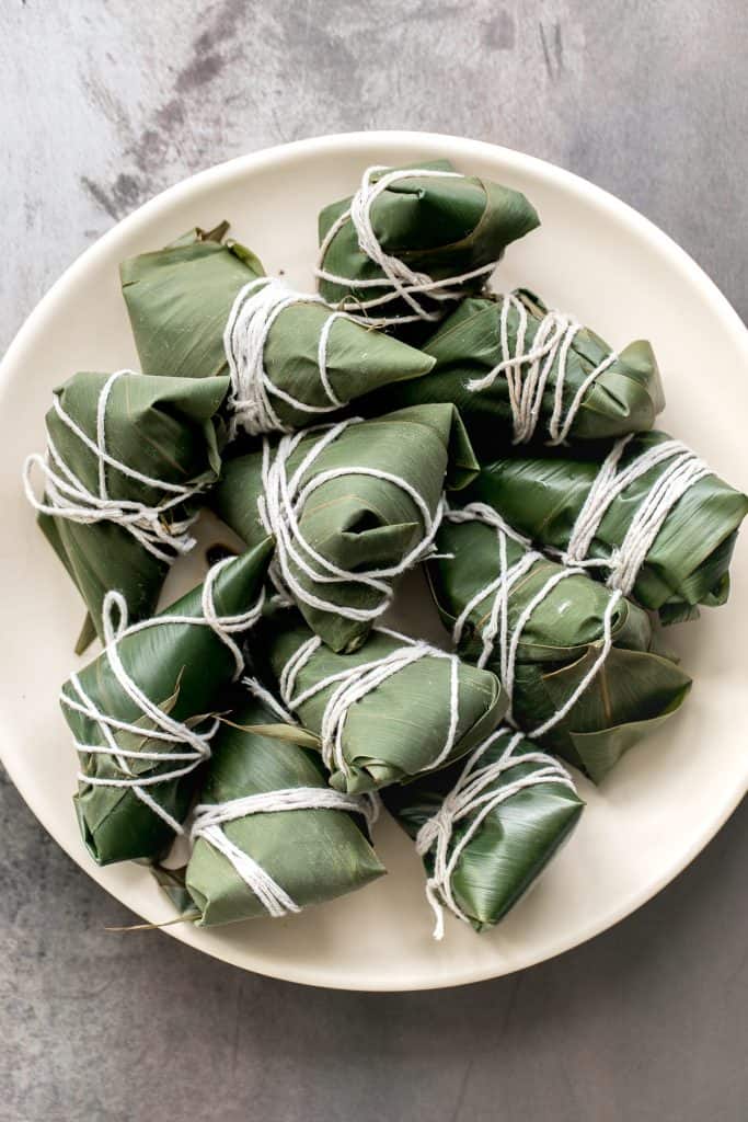 Zongzi Chinese tamales (粽子) or sticky rice dumplings are stuffed with sticky rice, pork belly, and shiitake mushrooms, wrapped inside reed or bamboo leaves. | aheadofthyme.com