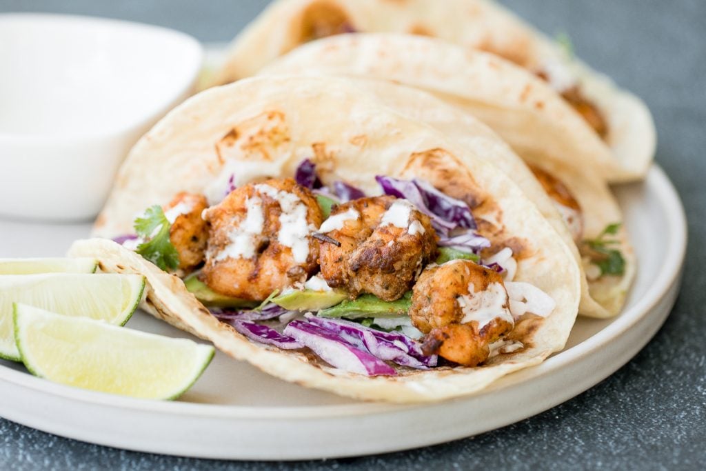 Quick and easy shrimp tacos with lime crema slaw are ready in less than 30 minutes and are packed with flavourful crispy shrimp and creamy cabbage slaw. | aheadofthyme.com