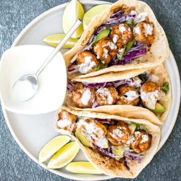 Quick and easy shrimp tacos with lime crema slaw are ready in less than 30 minutes and are packed with flavourful crispy shrimp and creamy cabbage slaw. | aheadofthyme.com