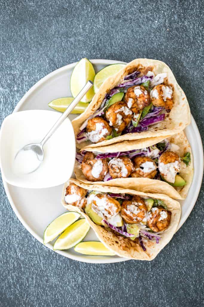 Quick and easy shrimp tacos with lime crema slaw are ready in less than 30 minutes and are packed with flavourful crispy shrimp and creamy cabbage slaw. | aheadofthyme.com