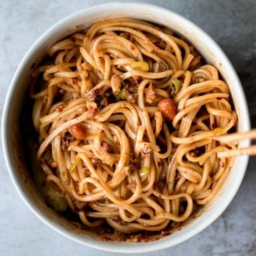 Toss thin wheat noodles in a spicy chili oil sauce and top with seasoned ground beef to make numbing, spicy Sichuan Dan Dan noodles in under 15 minutes. | aheadofthyme.com