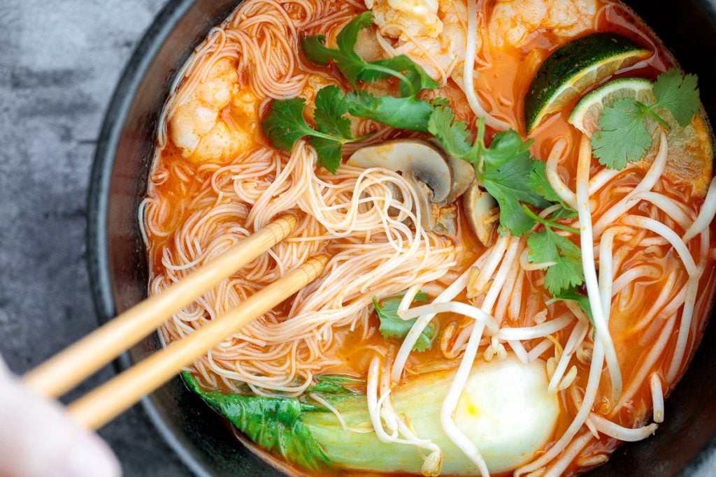 This gluten-free, one pot Thai red curry noodle soup is so flavourful and packed with shrimp, vermicelli rice noodles, fresh herbs, lime juice + fish sauce. | aheadofthyme.com