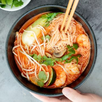 This gluten-free, one pot Thai red curry noodle soup is so flavourful and packed with shrimp, vermicelli rice noodles, fresh herbs, lime juice + fish sauce. | aheadofthyme.com