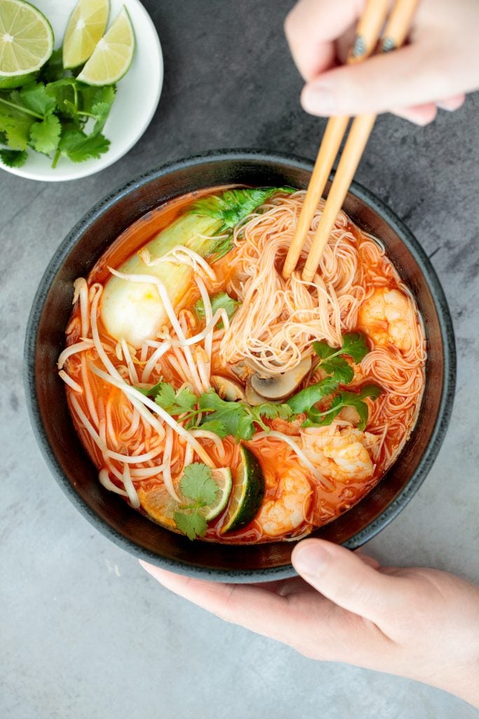 This gluten-free, one pot Thai red curry noodle soup is so flavourful and packed with shrimp, vermicelli rice noodles, fresh herbs, lime juice + fish sauce. | aheadofthyme.com