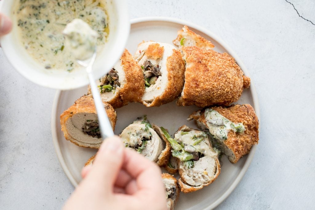 Give your chicken breasts an upgrade by stuffing them to make fancy, juicy chicken roulade with spinach and mushrooms topped with a creamy alfredo sauce. | aheadofthyme.com