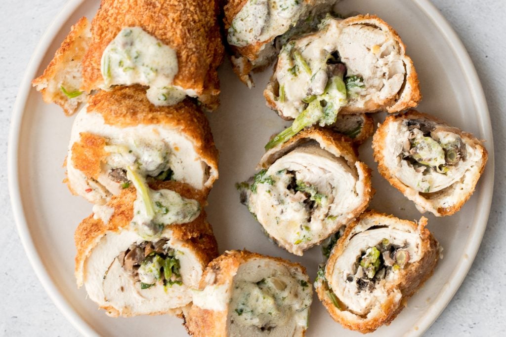 Give your chicken breasts an upgrade by stuffing them to make fancy, juicy chicken roulade with spinach and mushrooms topped with a creamy alfredo sauce. | aheadofthyme.com