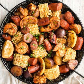 Easy, garlicky and buttery grilled shrimp boil with prawns, corn, baby potatoes and sausage, seasoned and tossed with parsley takes just 20 minutes to cook. | aheadofthyme.com