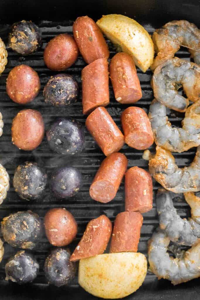 Easy Grilled Shrimp Boil is the ultimate summer meal: loaded with prawns, corn, and sausage, tossed in buttery garlic and herbs. Ready in 30 minutes! | aheadofthyme.com