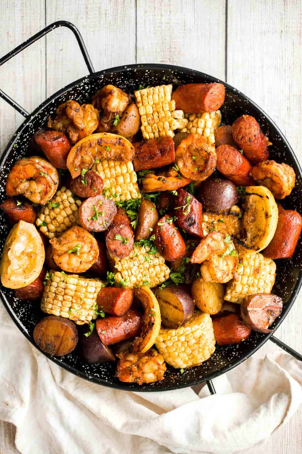 Easy Grilled Shrimp Boil is the ultimate summer meal: loaded with prawns, corn, and sausage, tossed in buttery garlic and herbs. Ready in 30 minutes! | aheadofthyme.com