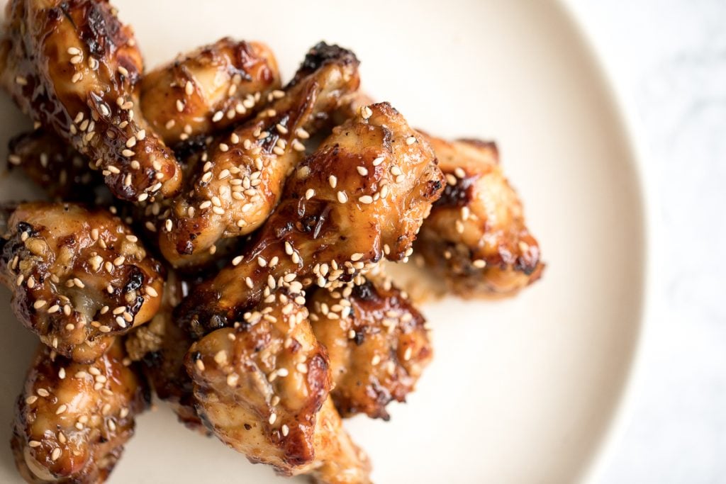 These sweet and sticky honey garlic chicken wings are baked or air fried until crispy and tossed in a honey garlic sauce. So addictive and so easy to make. | aheadofthyme.com