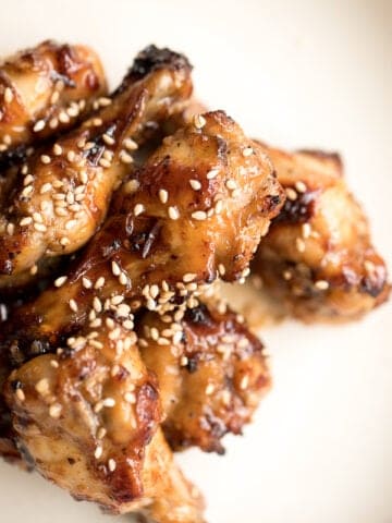These sweet and sticky honey garlic chicken wings are baked or air fried until crispy and tossed in a honey garlic sauce. So addictive and so easy to make. | aheadofthyme.com