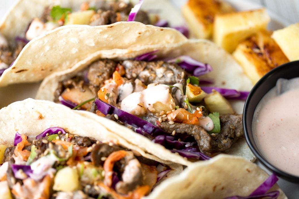 Fusion-style Korean beef steak tacos are made with tender, flavour-packed slices of beef and topped with caramelized pineapple, kimchi, and spicy mayo. | aheadofthyme.com