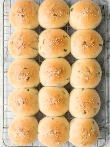 Soft and fluffy, quick dinner bread rolls are loaded with green onions and topped with flaked sea salt and sesame seeds. Ready in just 1.5 hours. | aheadofthyme.com