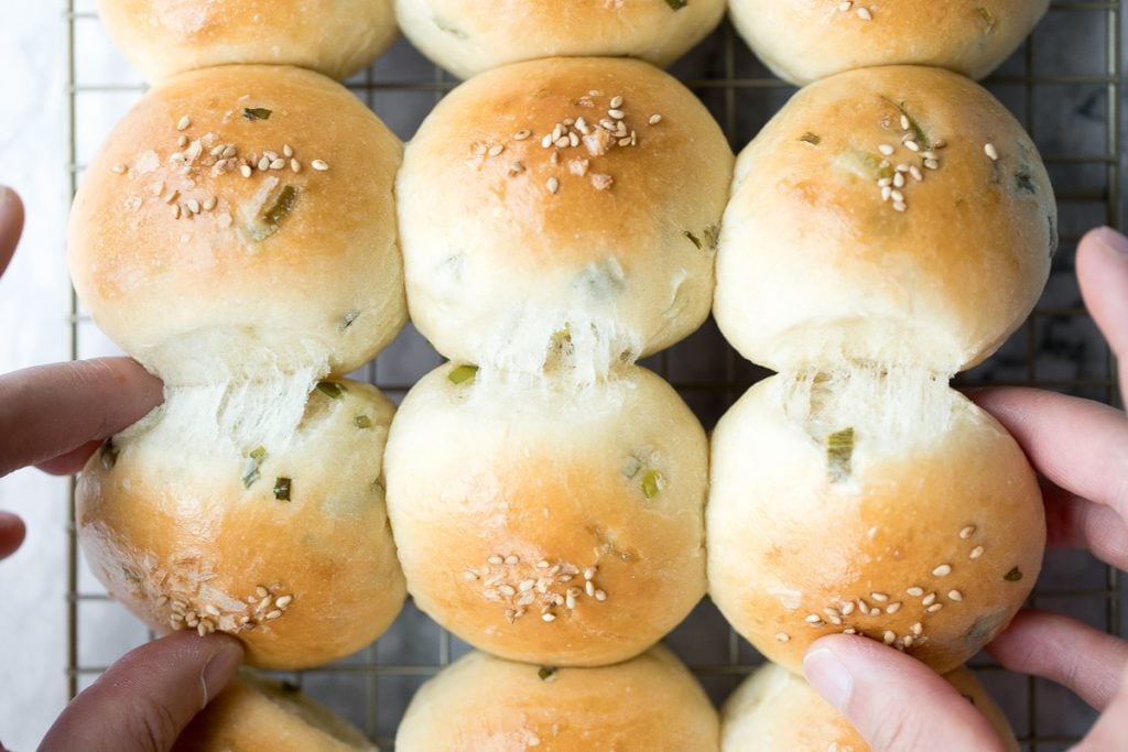 Soft and fluffy, quick dinner bread rolls are loaded with green onions and topped with flaked sea salt and sesame seeds. Ready in just 1.5 hours. | aheadofthyme.com