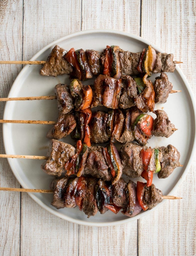 Easy Greek souvlaki beef shish kebabs are marinated in a garlicky lemony olive oil marinade and threaded with fresh vegetables. Cook on the grill or oven. | aheadofthyme.com