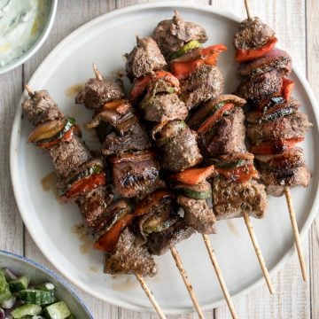 Easy Greek souvlaki beef shish kebabs are marinated in a garlicky lemony olive oil marinade and threaded with fresh vegetables. Cook on the grill or oven. | aheadofthyme.com