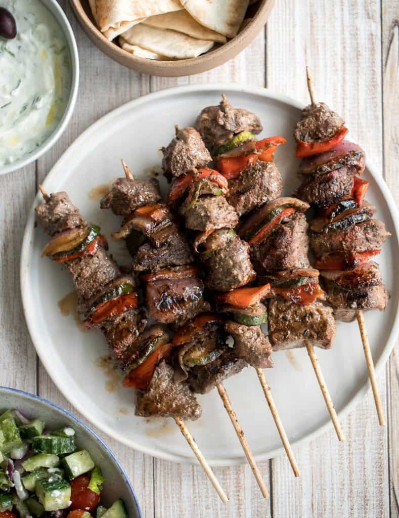 Easy Greek souvlaki beef shish kebabs are marinated in a garlicky lemony olive oil marinade and threaded with fresh vegetables. Cook on the grill or oven. | aheadofthyme.com