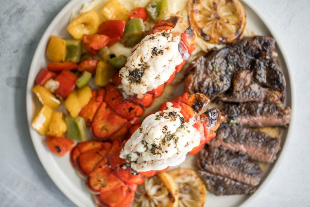 Fancy, restaurant-quality surf and turf is super easy to make with fresh lobster tail and tender rib-eye steak with a delicious garlic butter sauce. | aheadofthyme.com