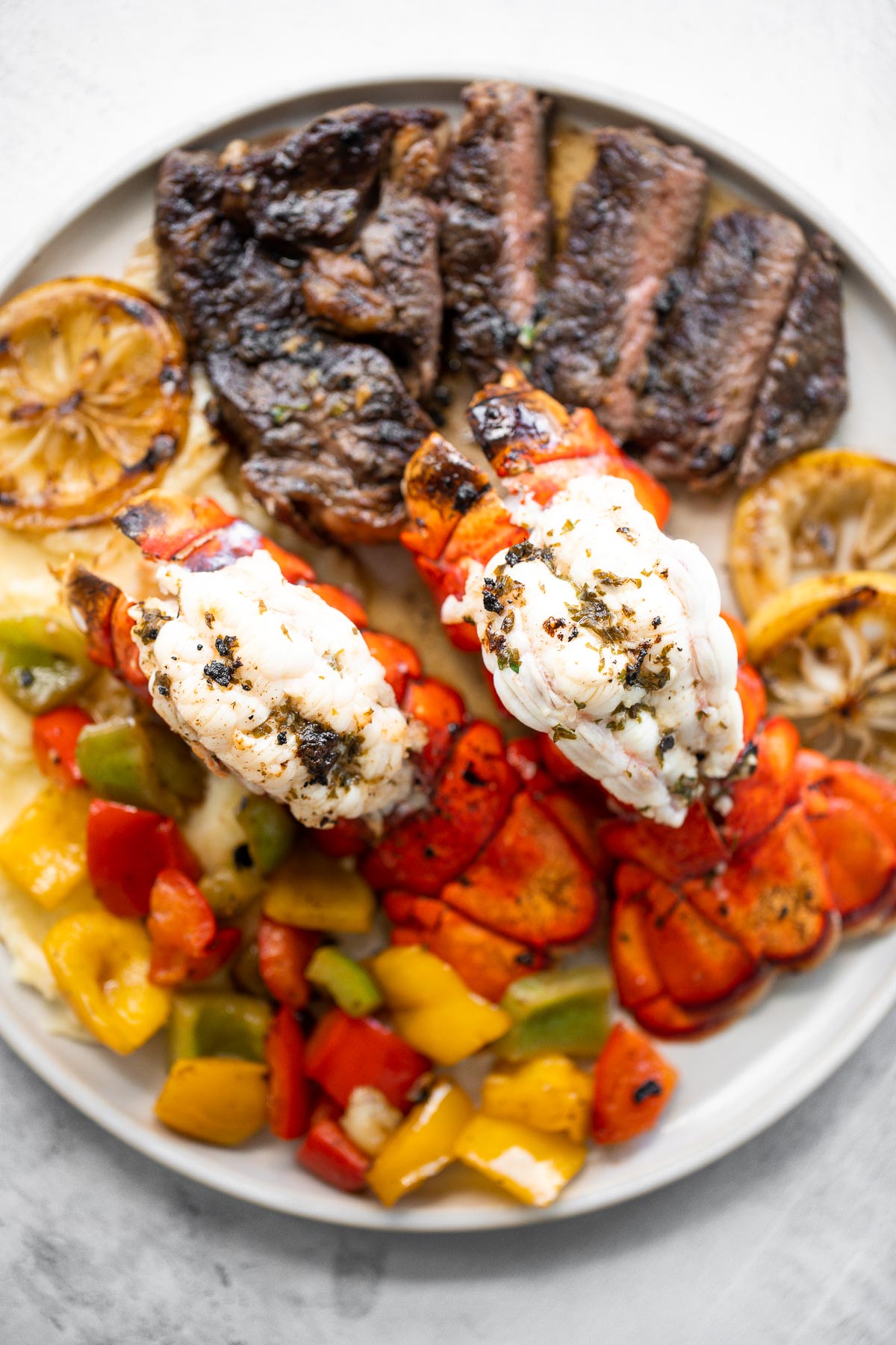 Fancy, restaurant-quality surf and turf is super easy to make with fresh lobster tail and tender rib-eye steak with a delicious garlic butter sauce. | aheadofthyme.com