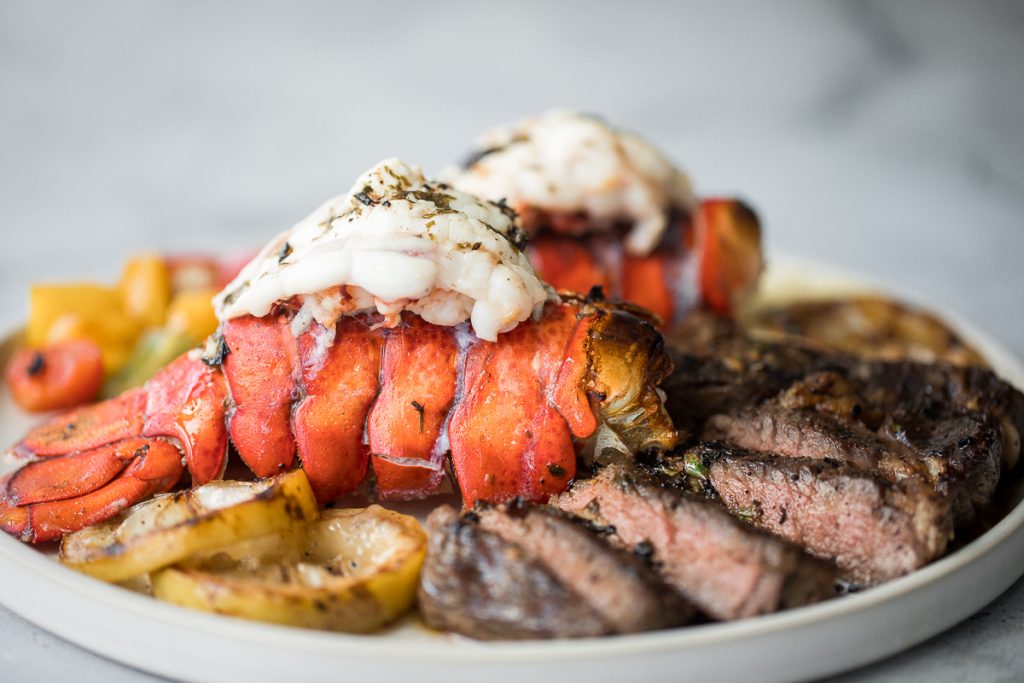Fancy, restaurant-quality surf and turf is super easy to make with fresh lobster tail and tender rib-eye steak with a delicious garlic butter sauce. | aheadofthyme.com 