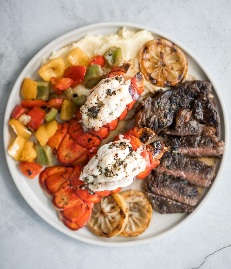 Fancy, restaurant-quality surf and turf is super easy to make with fresh lobster tail and tender rib-eye steak with a delicious garlic butter sauce. | aheadofthyme.com