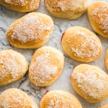 These melt-in-your-mouth, homemade baked jelly donuts, coated in sugar and filled with sweet strawberry jam, are so soft, fluffy, spongy and airy. | aheadofthyme.com