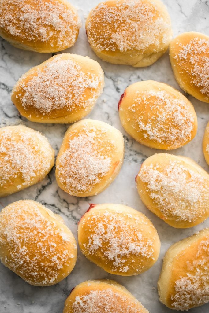 These melt-in-your-mouth, homemade baked jelly donuts, coated in sugar and filled with sweet strawberry jam, are so soft, fluffy, spongy and airy. | aheadofthyme.com