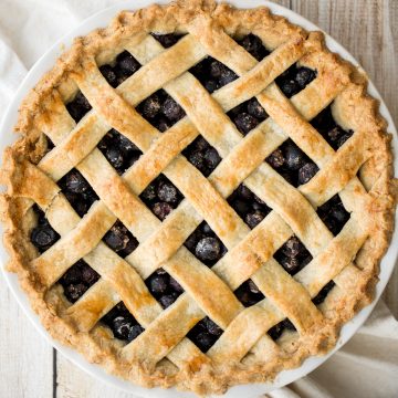 Summery classic blueberry pie is made with the perfect flaky pie crust, a jammy blueberry filling with a hint of lemon, and sealed with a lattice top. | aheadofthyme.com