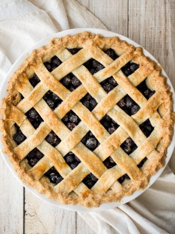 Summery classic blueberry pie is made with the perfect flaky pie crust, a jammy blueberry filling with a hint of lemon, and sealed with a lattice top. | aheadofthyme.com