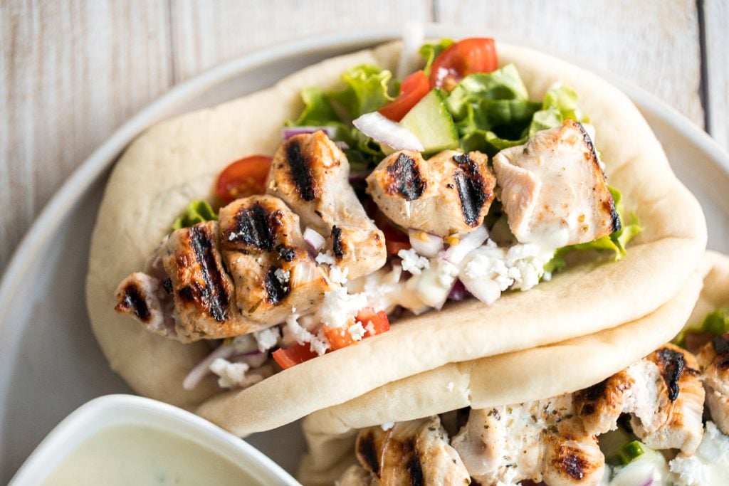 This refreshing and light, easy Greek chicken gyros is packed with tender souvlaki chicken, Greek salad, and homemade tzatziki sauce, all wrapped in a pita. | aheadofthyme.com